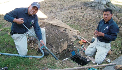 Two technicians working on pipes of an irrigation distribution system